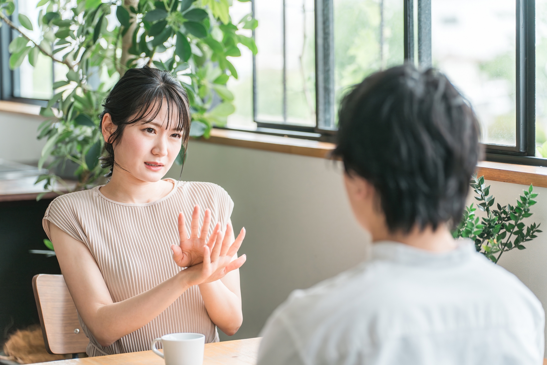 テーブルを挟んで話をする女性と男性